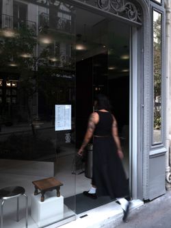 Entrance of WHITE Coffee - Paris 4 with glass door, modern interior, and a person entering the café.