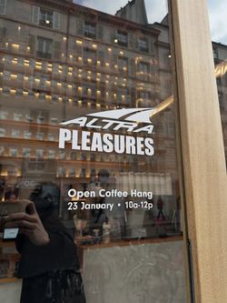Window of a coffee shop with event details for an Open Coffee Hang on 23 January from 10 am to 12 pm.