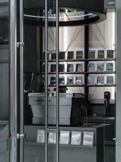 Intérieur moderne avec machine à café professionnelle et rangée de paquets de café au coffee shop WHITE Coffee - Paris 9.