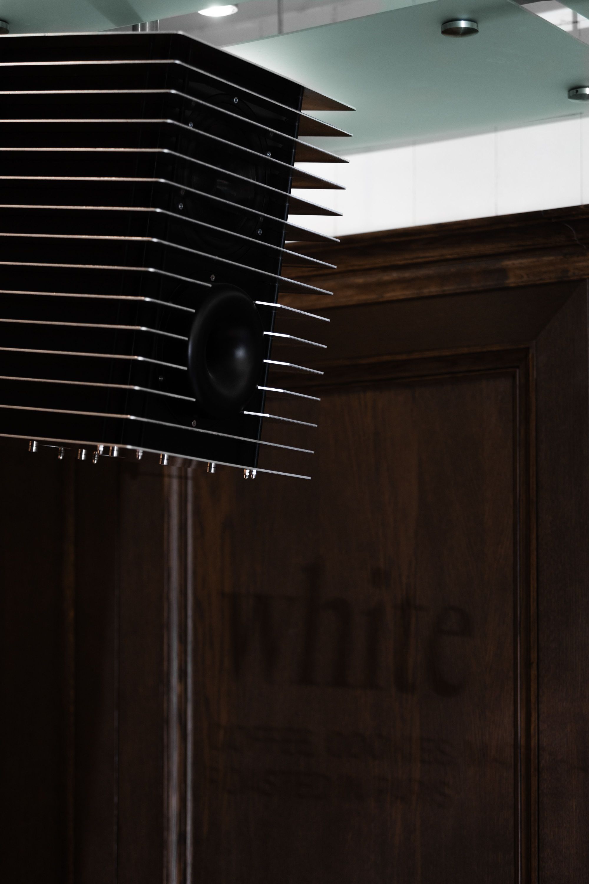Détail d'une installation design à l'intérieur du café WHITE Coffee - Paris 9 avec un mur en bois foncé.