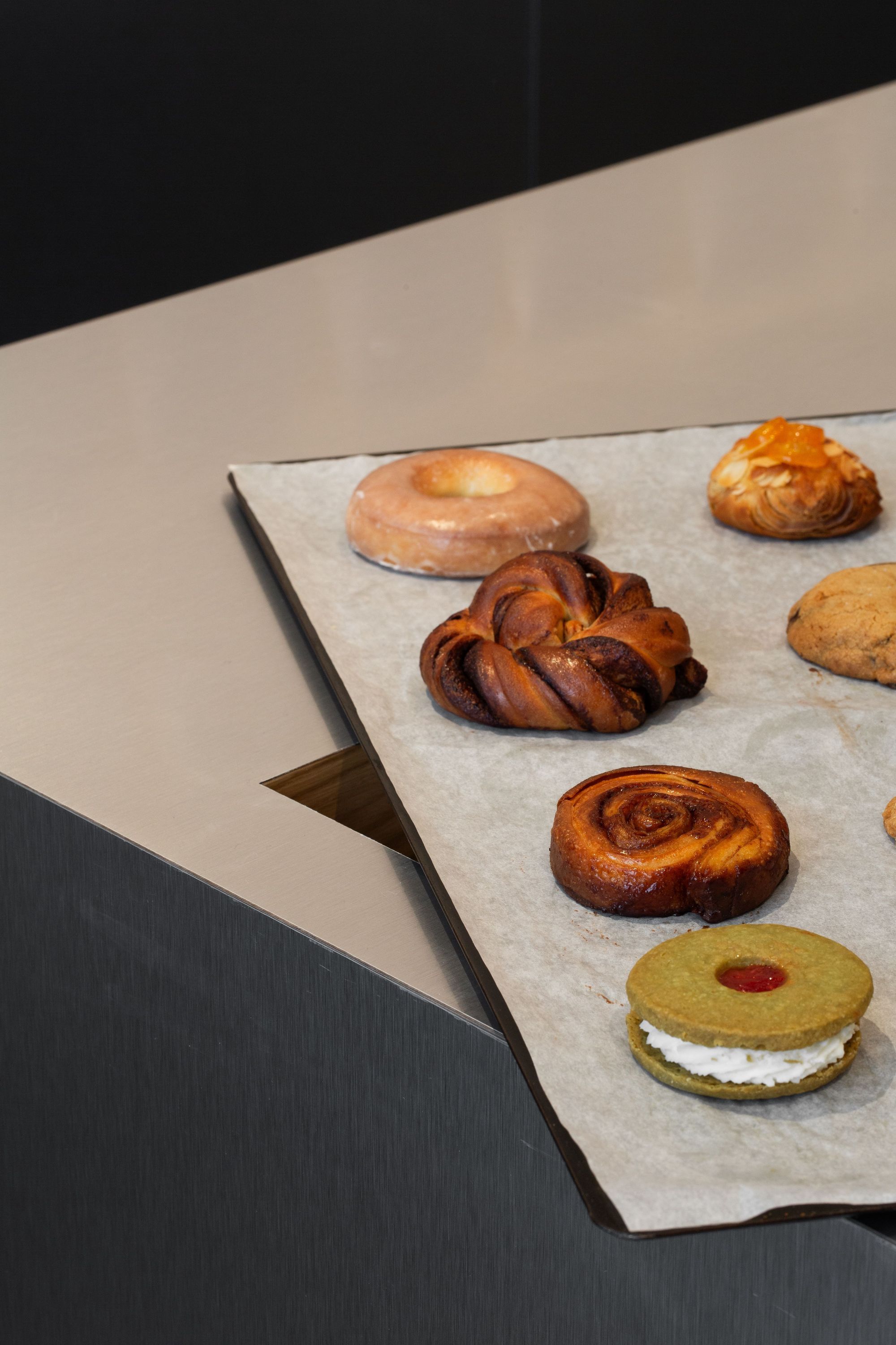 A barista serves customers behind a café counter at WHITE Coffee in Paris, showcasing a modern coffee shop atmosphere.