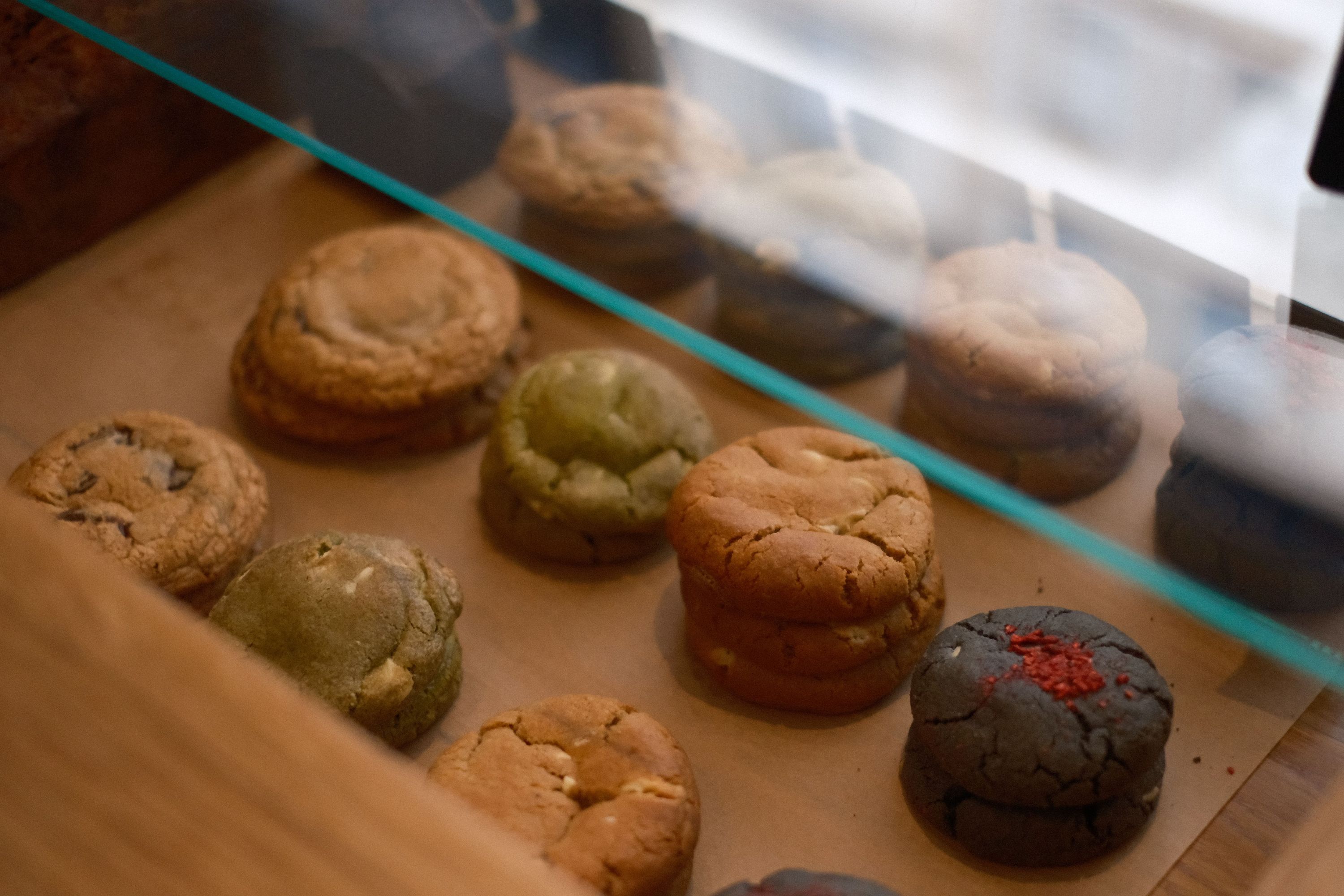 Assorted cookies displayed under glass at WHITE Coffee - Paris 3, a popular best coffee shop.