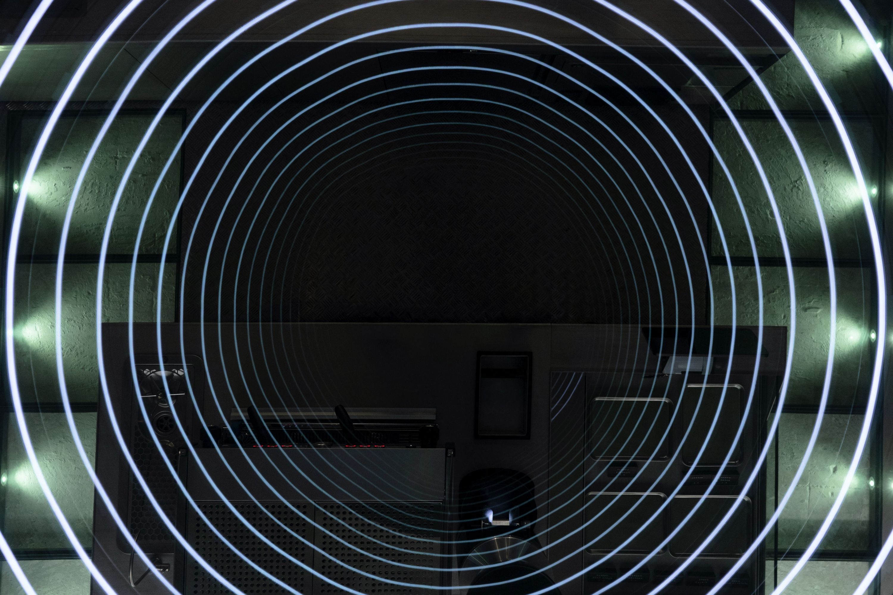 Concentric circular light rings on a dark ceiling with some wall lights visible on the sides