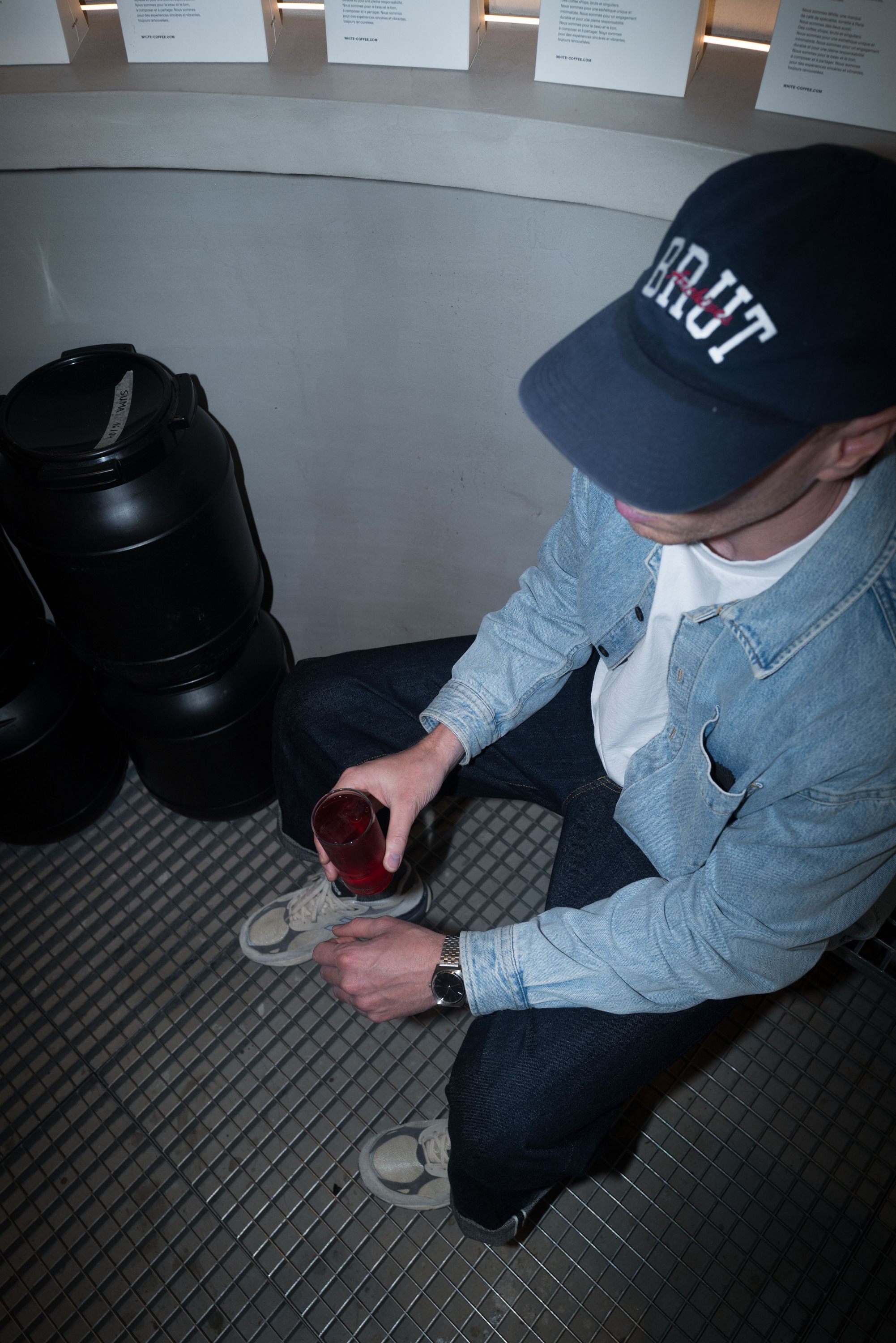 Client dans un café, portant une grande hat noire, devant le meilleur coffee shop à Paris.